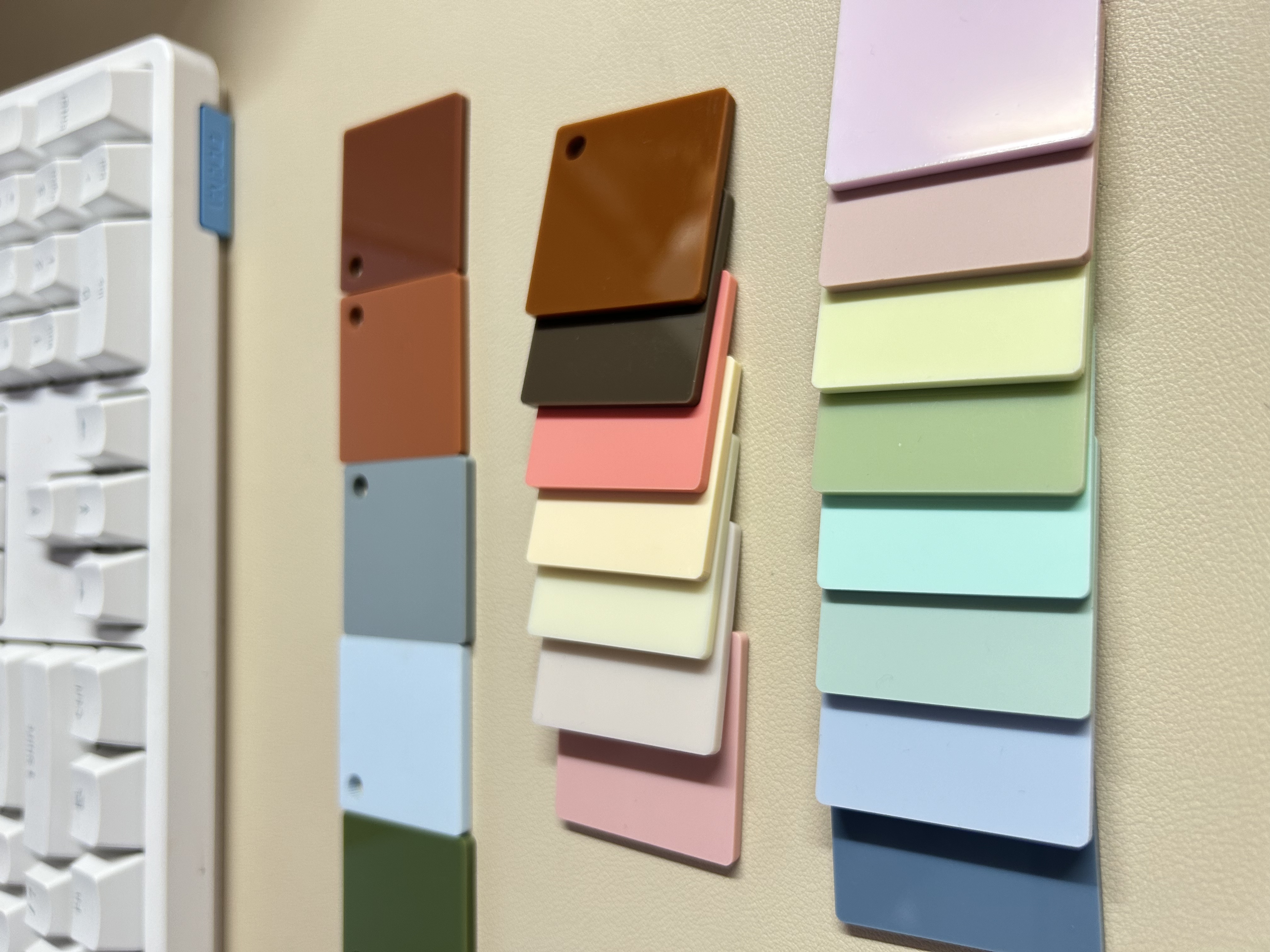 Physical opaque pastel acrylic sample chips arranged on a work surface.