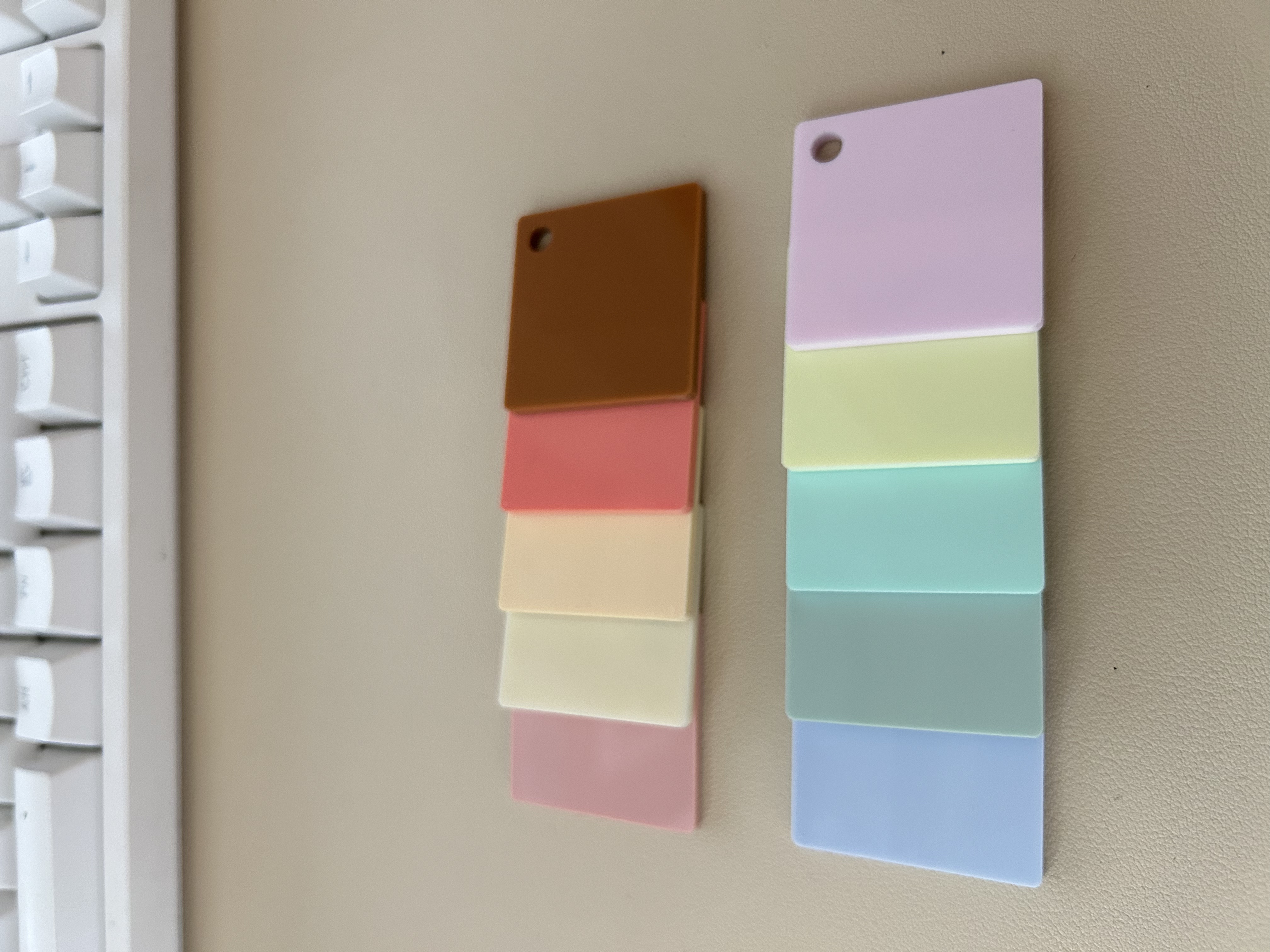 Physical opaque pastel acrylic sample chips in pastel and warm colors.
